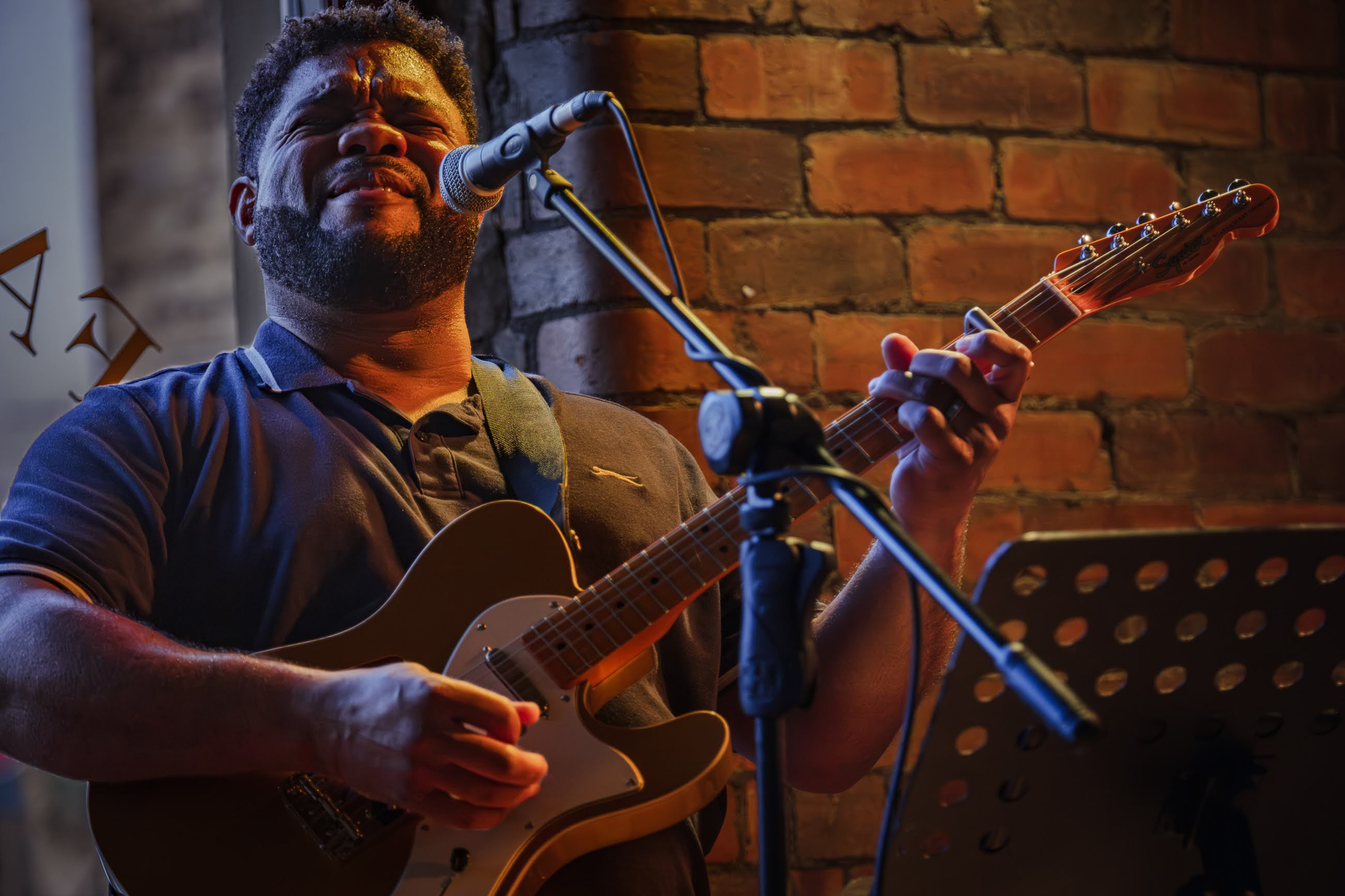 A musician singing and playing guitar